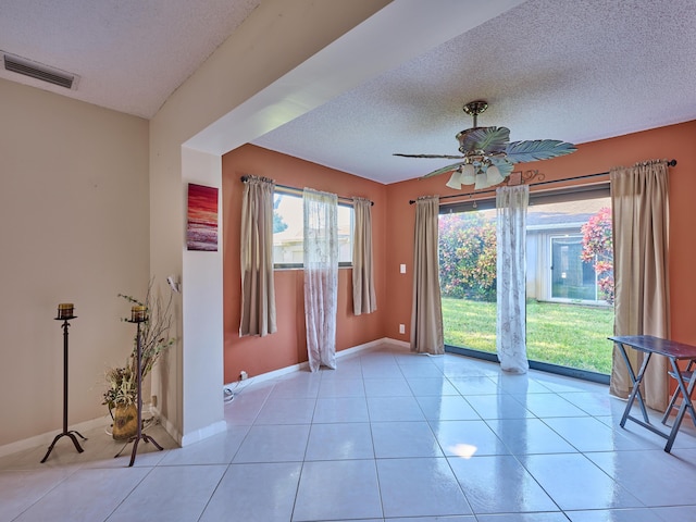 interior space with ceiling fan and a textured ceiling