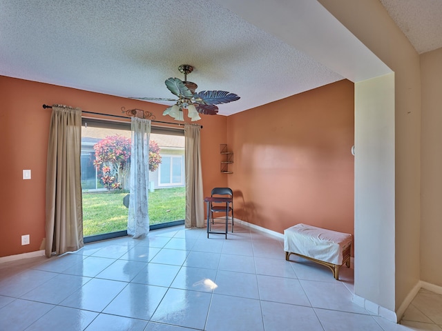 unfurnished room with light tile patterned floors, a textured ceiling, and ceiling fan