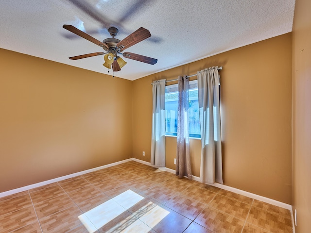 tiled empty room featuring ceiling fan and a textured ceiling