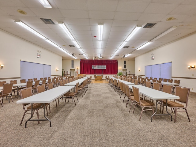 dining area featuring a paneled ceiling and carpet floors