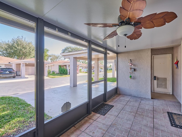 unfurnished sunroom with ceiling fan and plenty of natural light