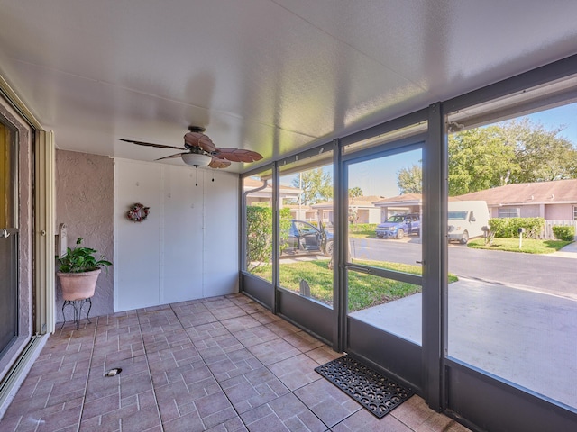 unfurnished sunroom with ceiling fan