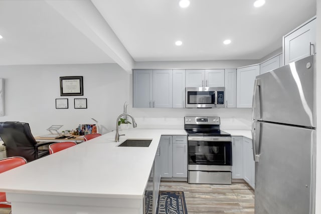 kitchen featuring light hardwood / wood-style floors, sink, gray cabinets, and stainless steel appliances