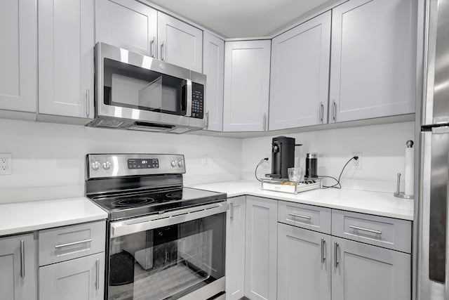 kitchen with appliances with stainless steel finishes and gray cabinetry