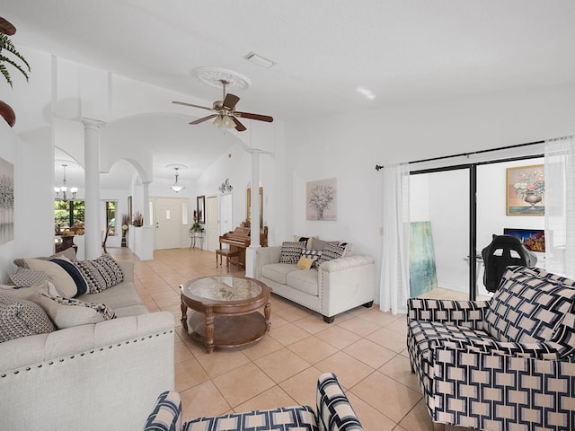 living room with light tile patterned flooring, ceiling fan with notable chandelier, and decorative columns