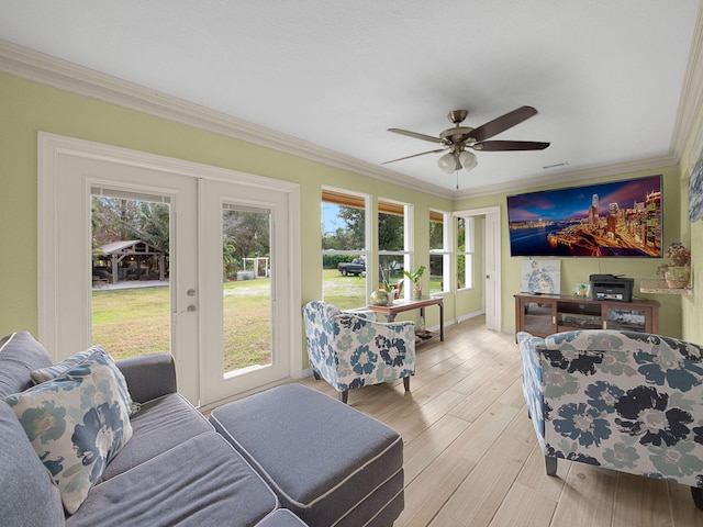 living room with crown molding, french doors, ceiling fan, and light wood-type flooring