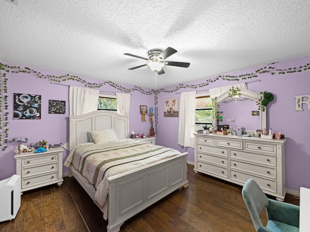 bedroom with multiple windows, ceiling fan, dark wood-type flooring, and a textured ceiling