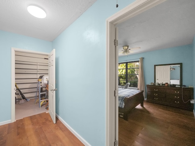 hallway with wood-type flooring and a textured ceiling