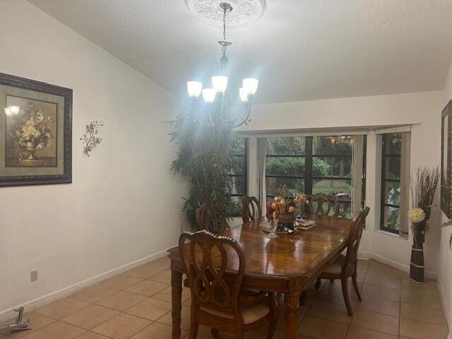 dining room with light tile patterned floors, lofted ceiling, and an inviting chandelier