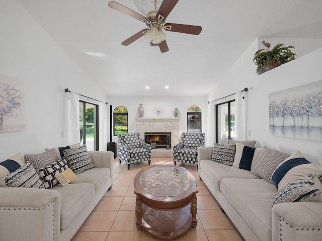 tiled living room with a fireplace, high vaulted ceiling, and ceiling fan