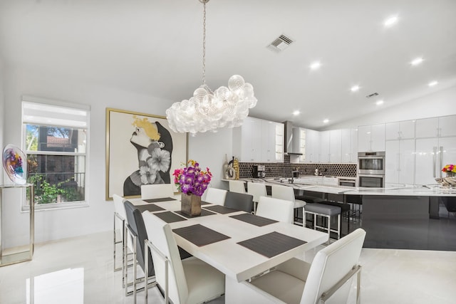 dining room with vaulted ceiling and a chandelier