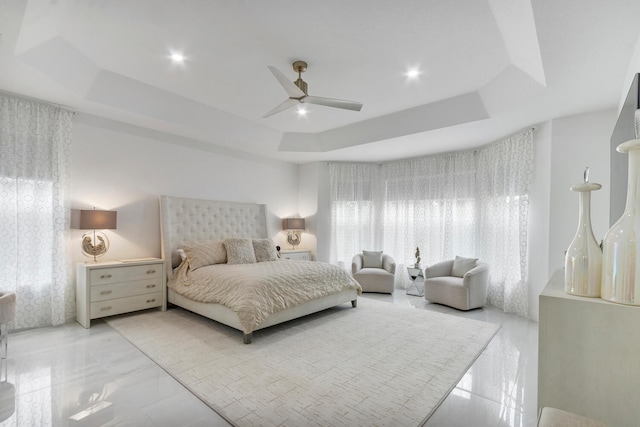 bedroom with ceiling fan and a tray ceiling