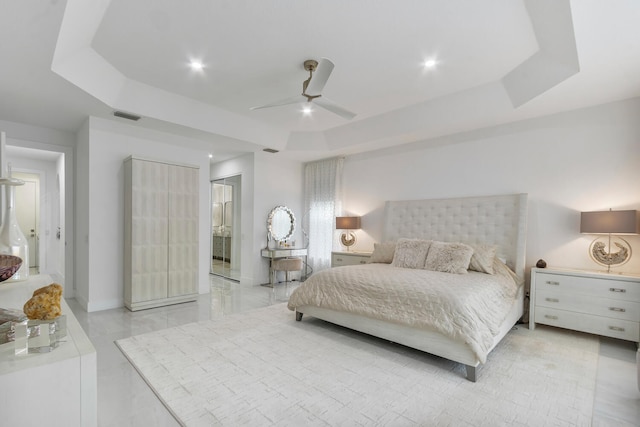 bedroom with ceiling fan and a tray ceiling