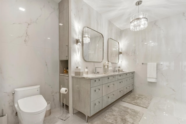 bathroom featuring toilet, vanity, tile walls, and a notable chandelier