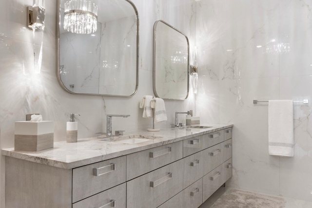 bathroom with a chandelier, tile walls, and vanity