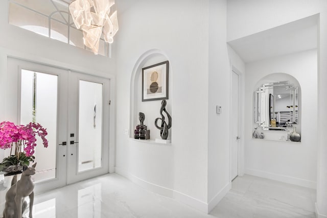 entryway featuring a high ceiling and french doors