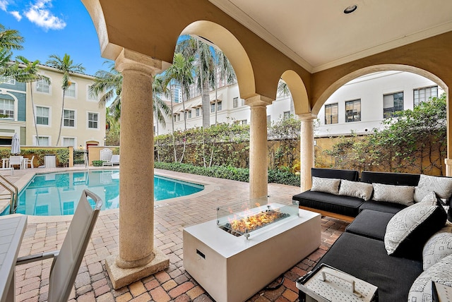 view of pool featuring an outdoor living space with a fire pit and a patio