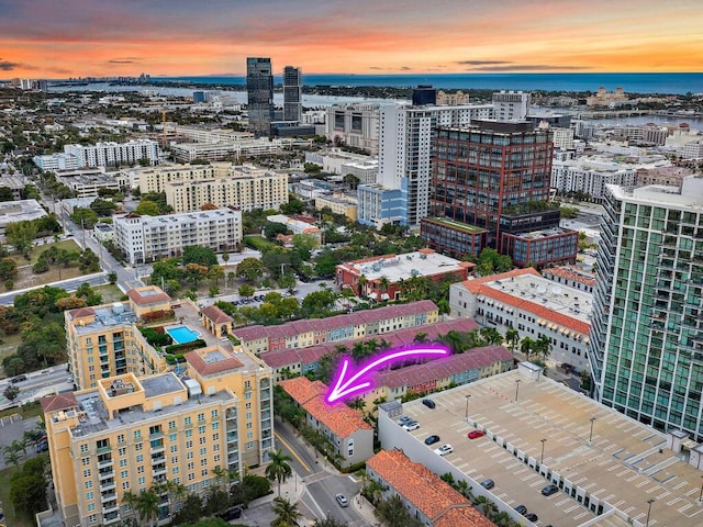 aerial view at dusk featuring a water view