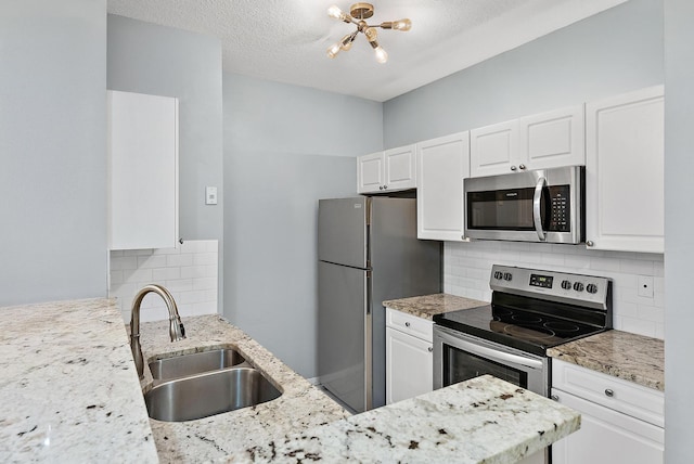 kitchen with white cabinetry, stainless steel appliances, backsplash, and sink