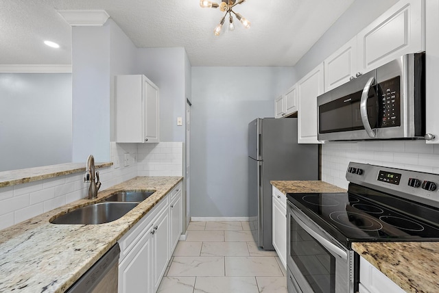 kitchen with tasteful backsplash, sink, white cabinetry, light stone countertops, and appliances with stainless steel finishes