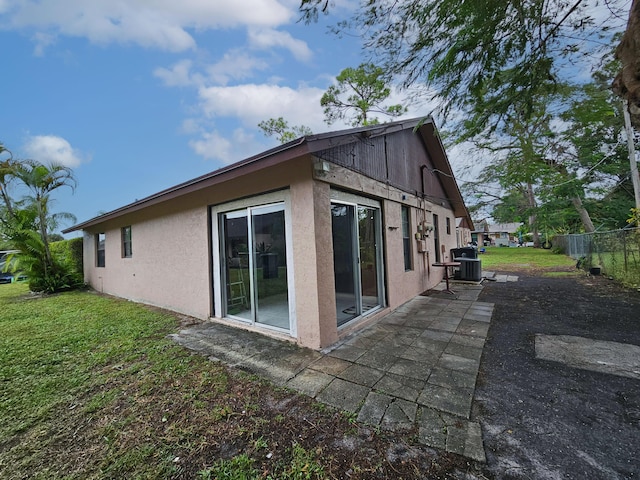 view of side of home featuring central air condition unit and a yard