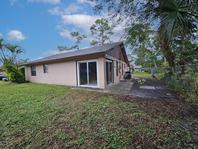 rear view of property with a yard, a patio, and cooling unit