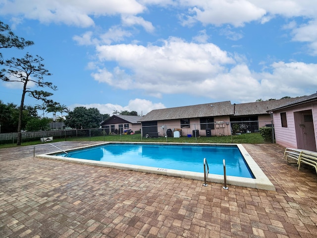 view of swimming pool with a yard and a patio