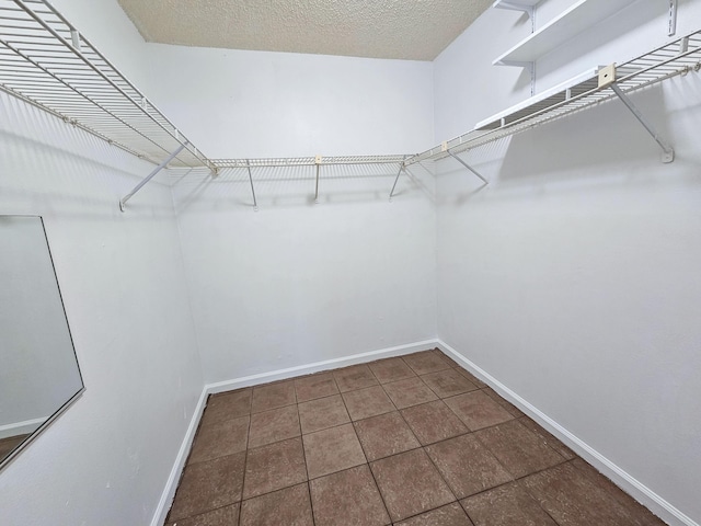 walk in closet featuring dark tile patterned floors