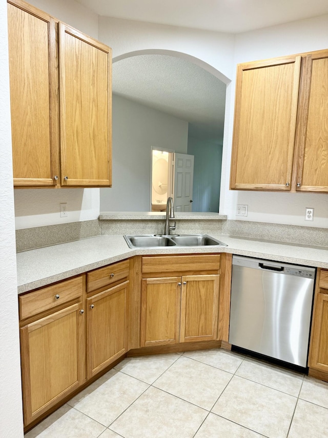 kitchen with light tile patterned flooring, stainless steel dishwasher, and sink