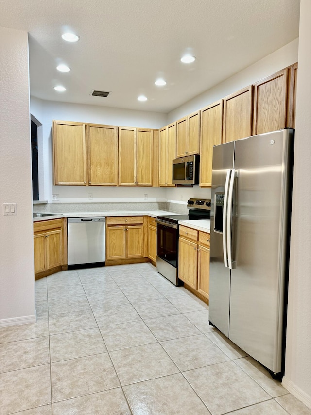 kitchen with light tile patterned floors, stainless steel appliances, and sink