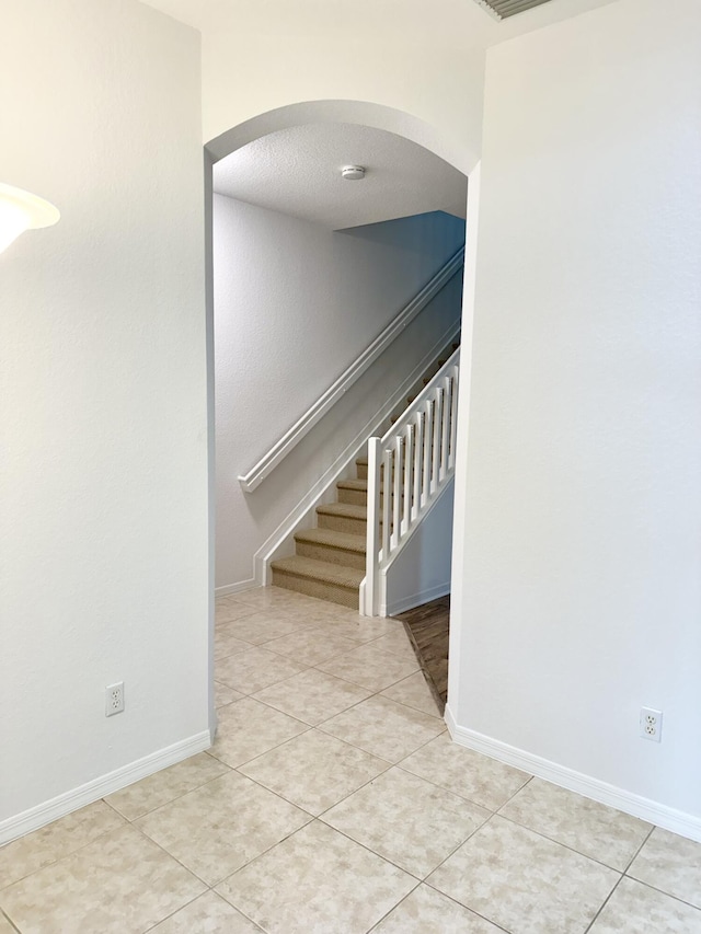 stairway with tile patterned floors