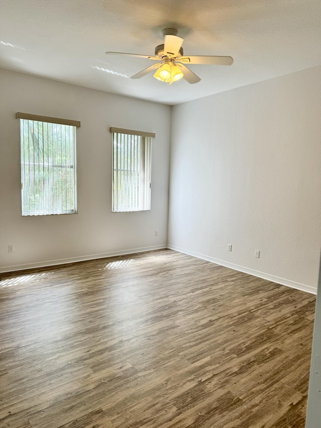 empty room featuring ceiling fan and dark hardwood / wood-style floors