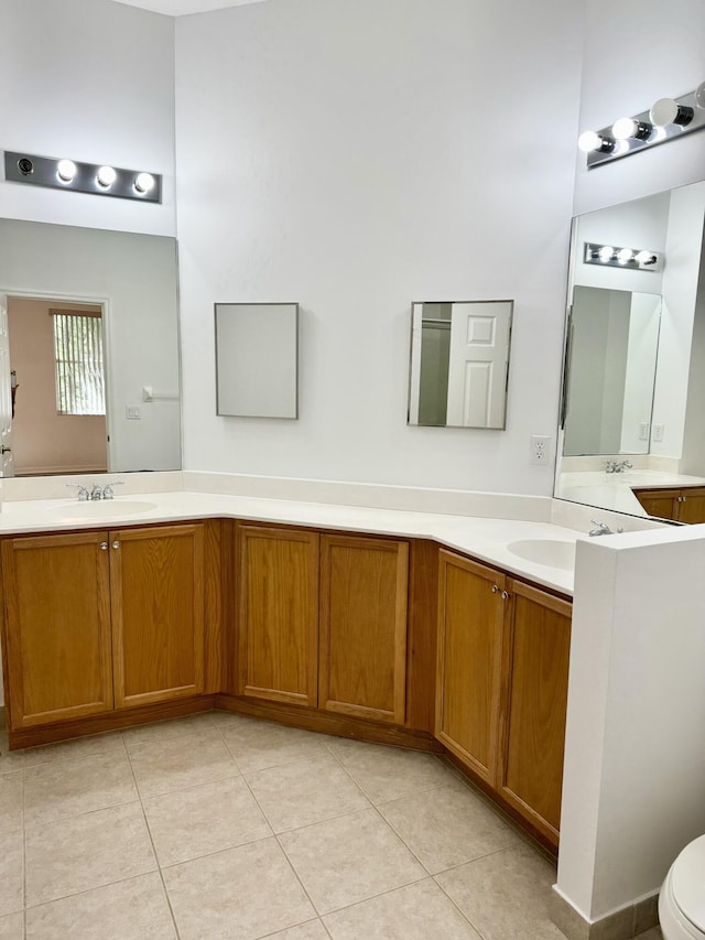 bathroom with toilet, tile patterned flooring, and vanity