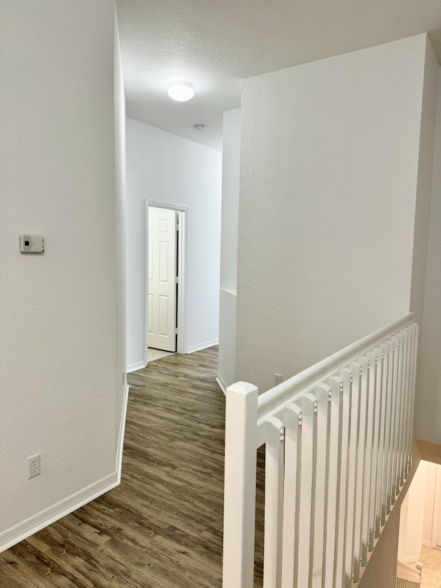 corridor with a textured ceiling, dark hardwood / wood-style floors, and radiator heating unit