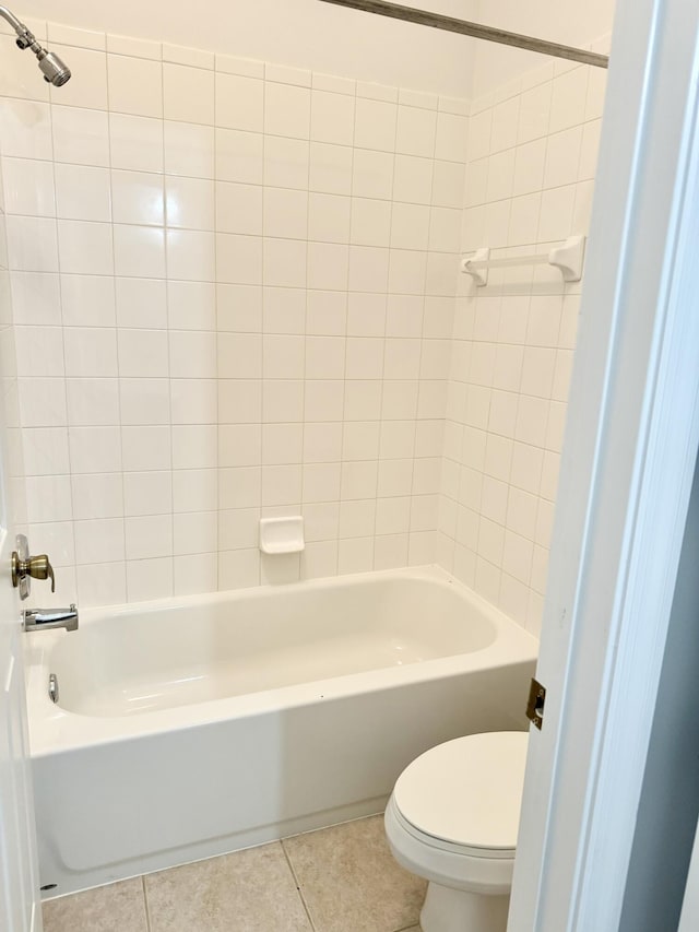 bathroom with toilet, tiled shower / bath combo, and tile patterned floors