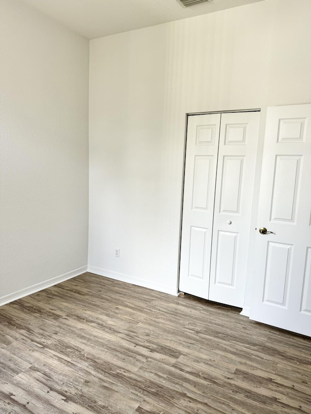 unfurnished bedroom featuring a closet and hardwood / wood-style floors