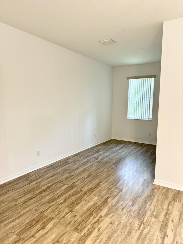 spare room featuring wood-type flooring