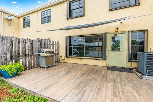 wooden deck featuring a grill and central air condition unit