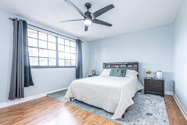 bedroom featuring a textured ceiling, ceiling fan, and wood-type flooring