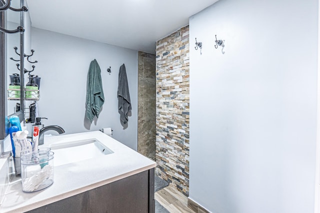 bathroom featuring walk in shower, vanity, and hardwood / wood-style floors