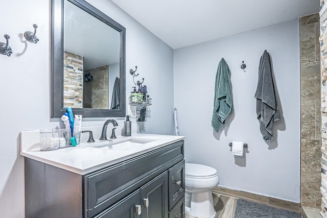 bathroom featuring wood-type flooring, toilet, vanity, and walk in shower