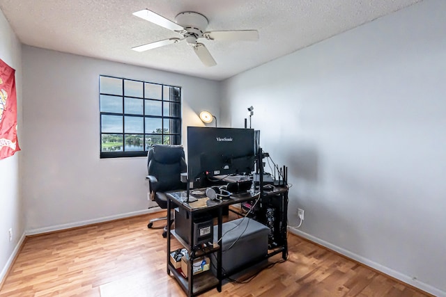 home office with a textured ceiling, ceiling fan, and light hardwood / wood-style floors