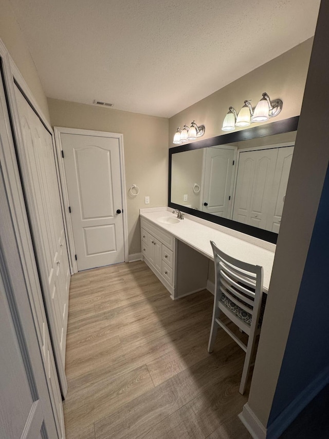 bathroom with vanity, hardwood / wood-style floors, and a textured ceiling