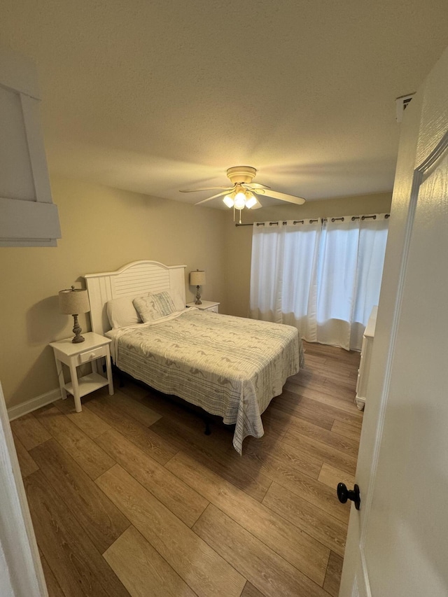 bedroom with ceiling fan and light hardwood / wood-style floors