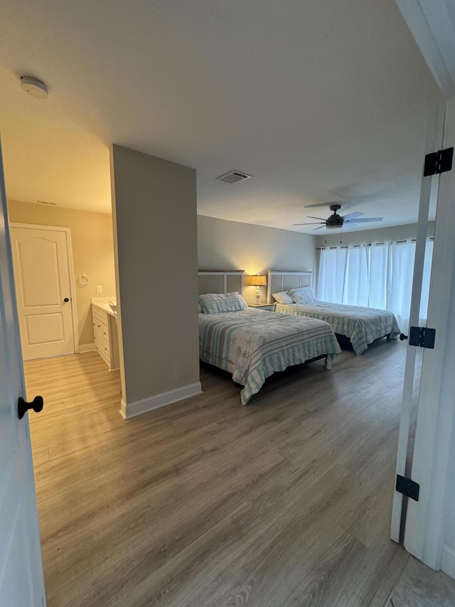 bedroom with visible vents, ceiling fan, baseboards, and wood finished floors