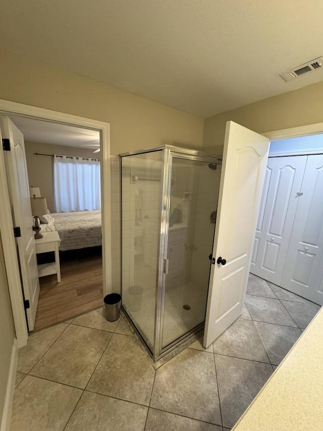 bathroom with a stall shower, tile patterned flooring, visible vents, and connected bathroom