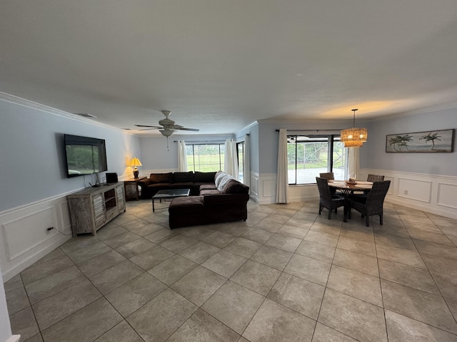 living area featuring ornamental molding, tile patterned flooring, and a wainscoted wall