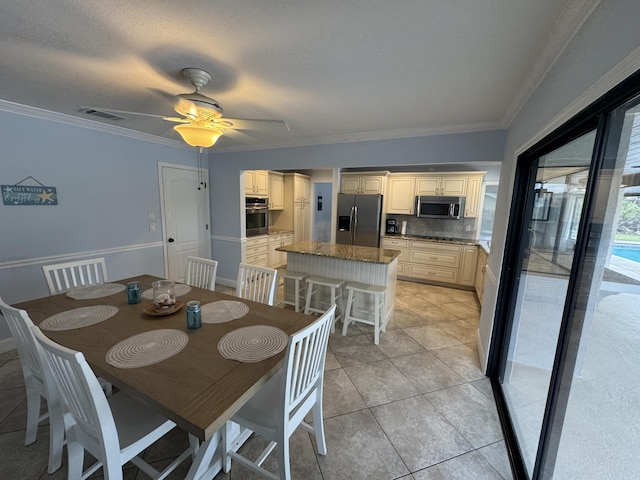 tiled dining area featuring crown molding and ceiling fan