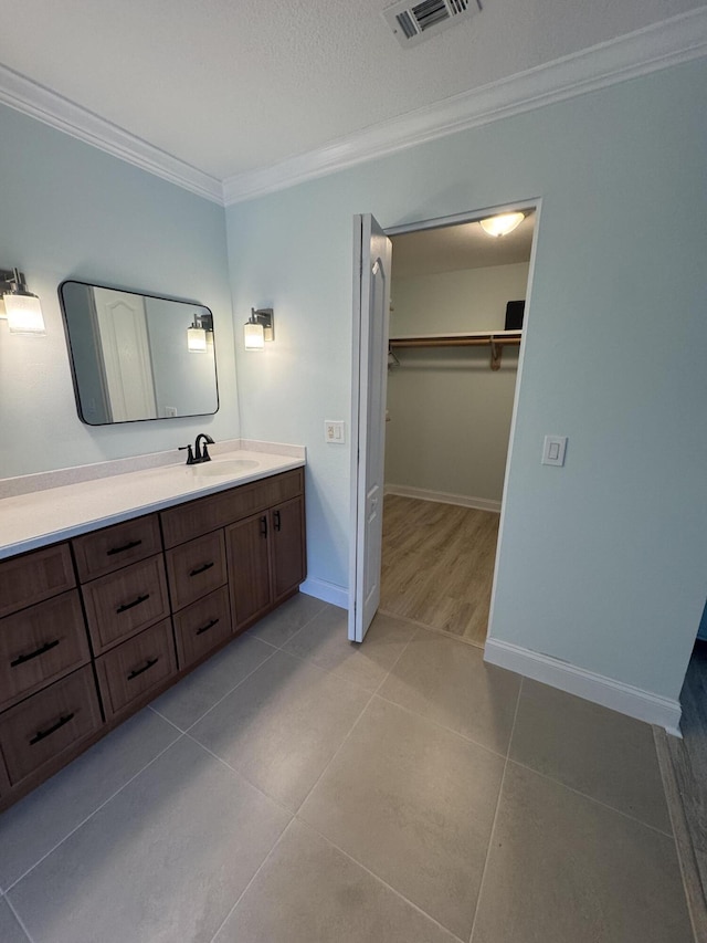 bathroom featuring vanity, tile patterned flooring, and crown molding