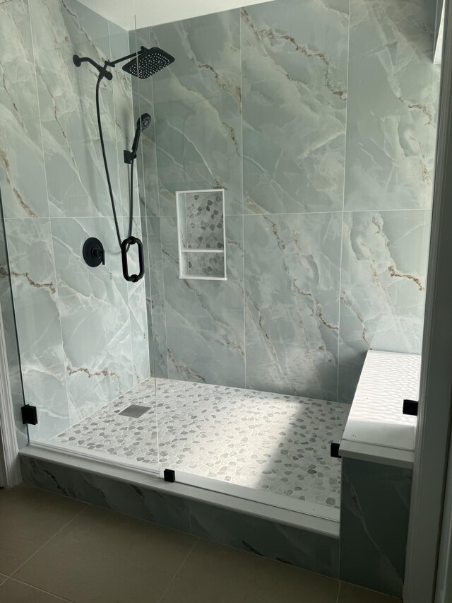 bathroom featuring a marble finish shower